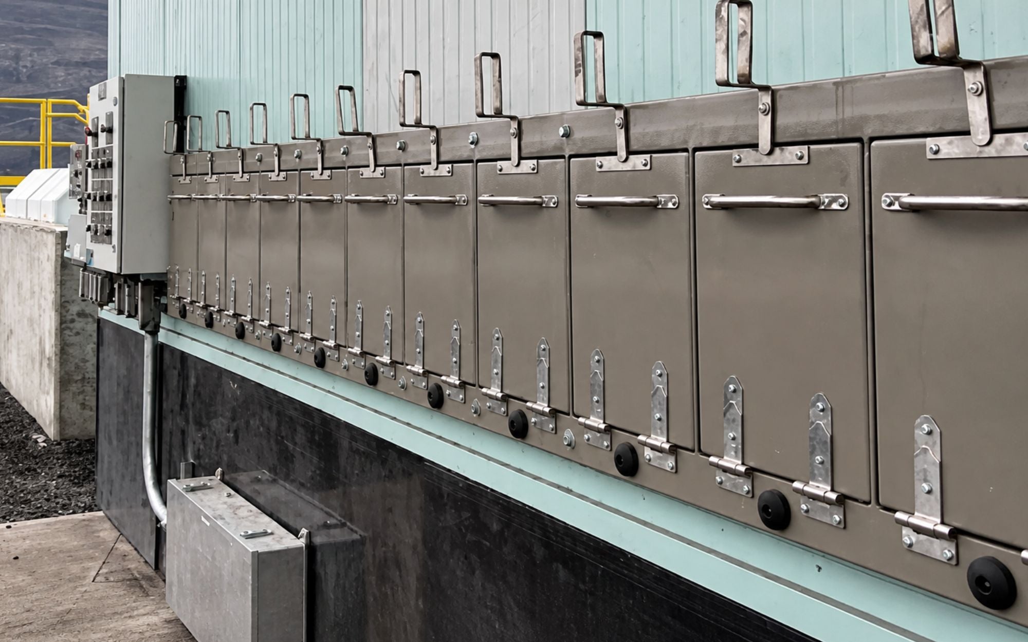 A row of labelled dispense cabinets running the length of an Innoflo lube island, with the control panel at the near end